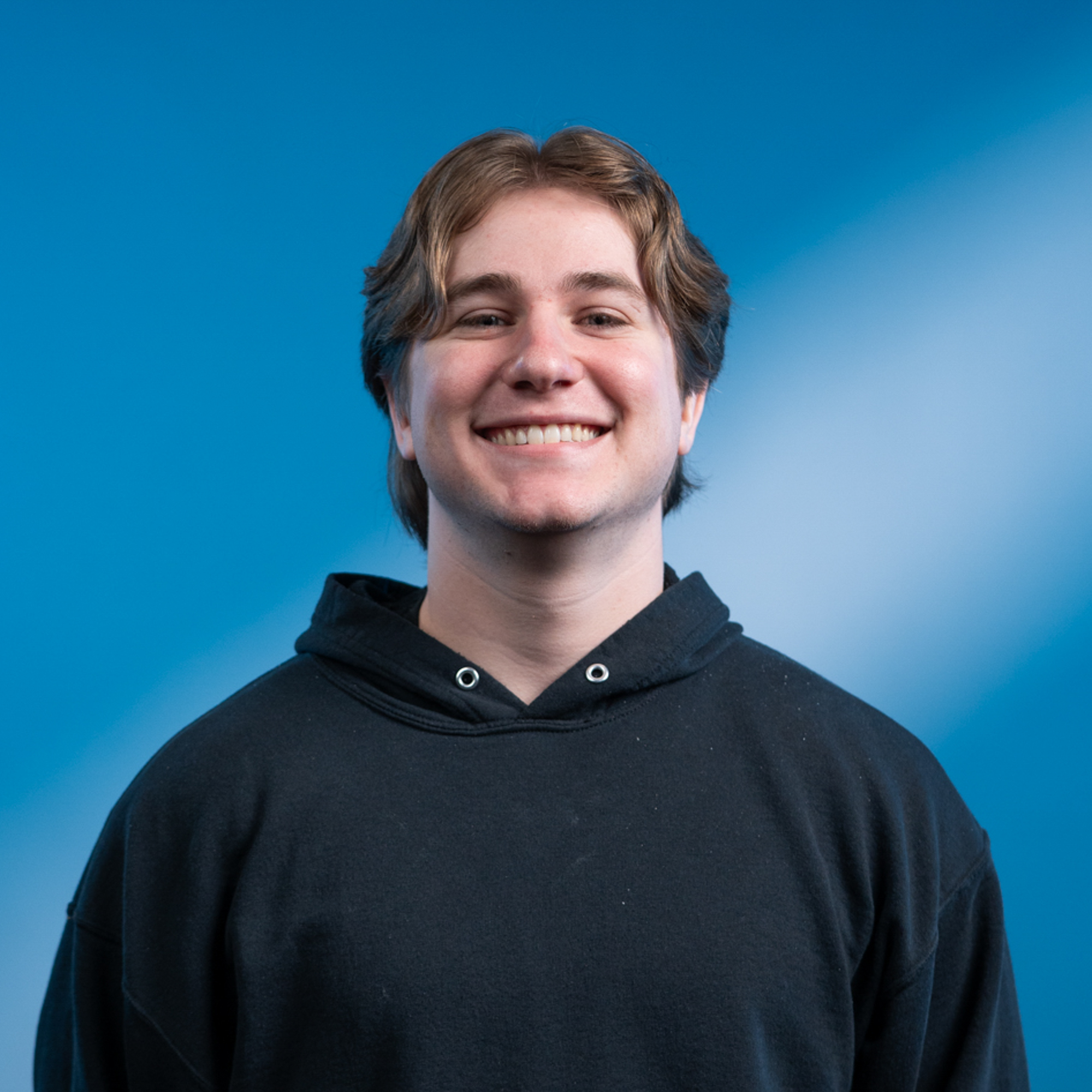A young white man with blonde-ish hair and brown eyes.