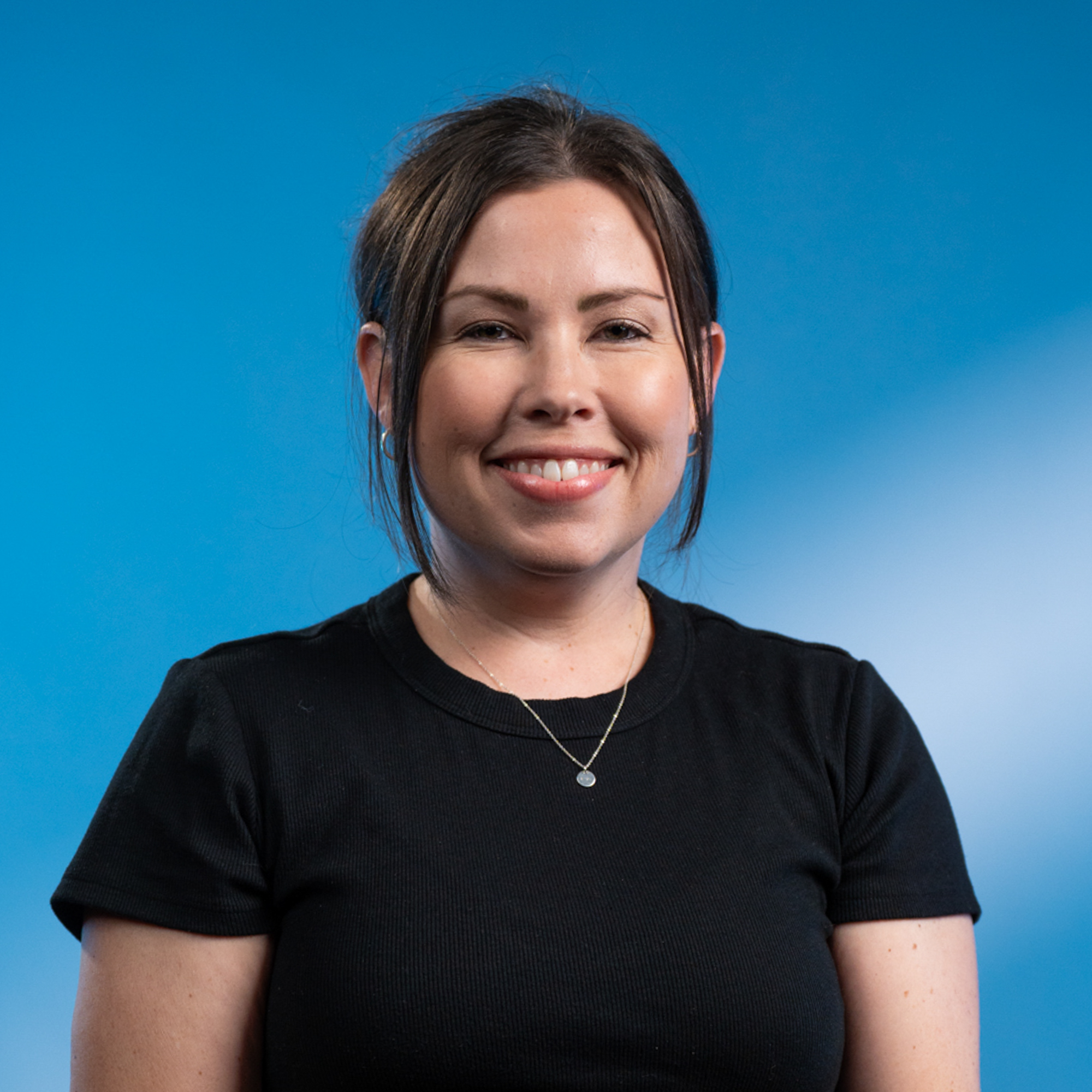 A middle-aged white woman with brown hair tied back and brown eyes.