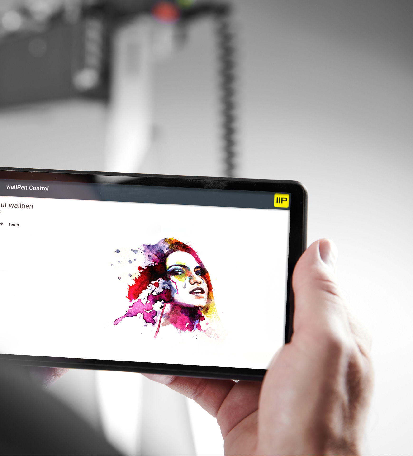 Person holding a tablet displaying a colorful watercolor portrait of a woman's face with splashes of red, purple, and yellow.