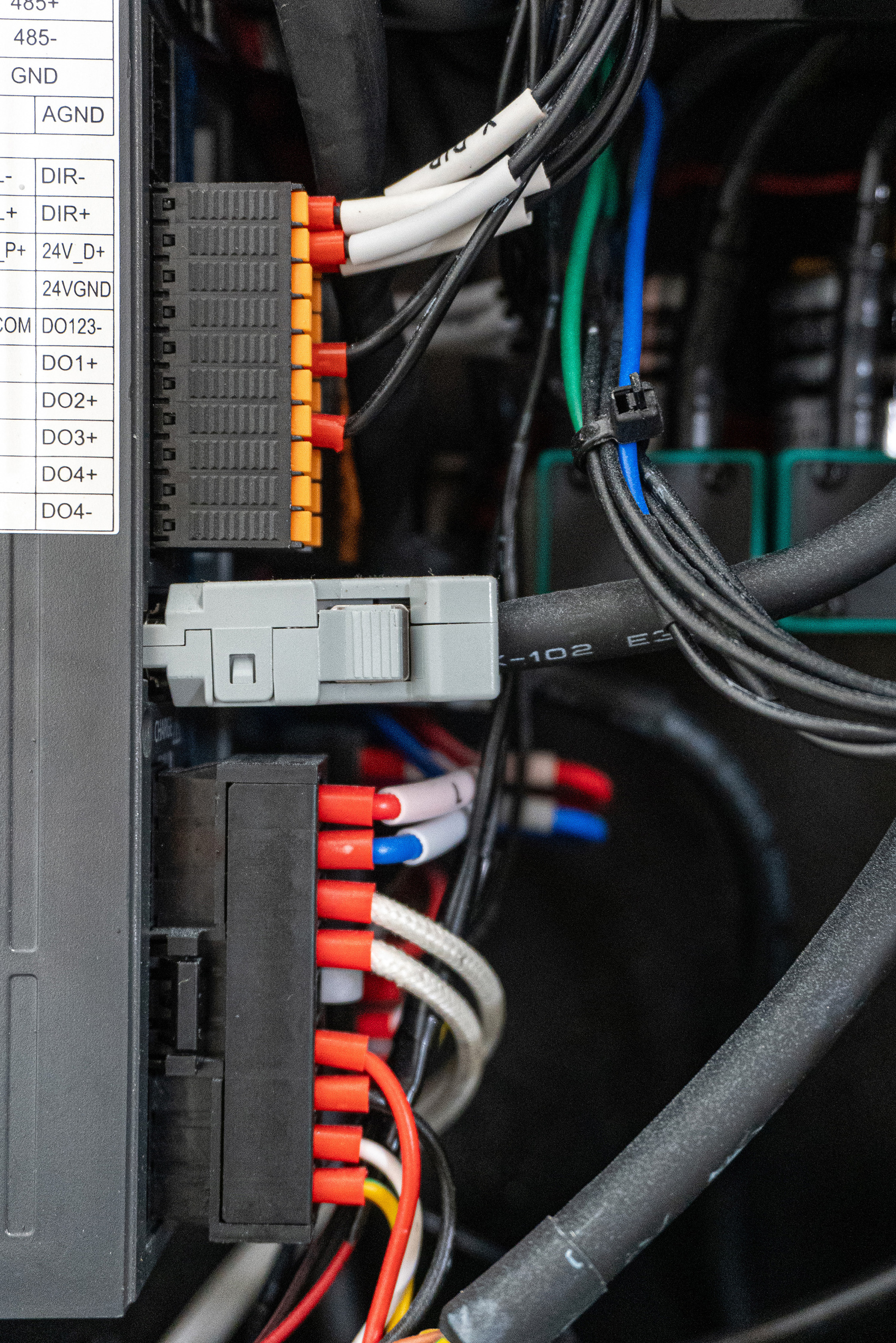 Close-up of a wallPen device with a plugged-in black coiled cable and a label showing values: diversity, sustainability, tolerance, equality, freedom of speech, and no to racism.