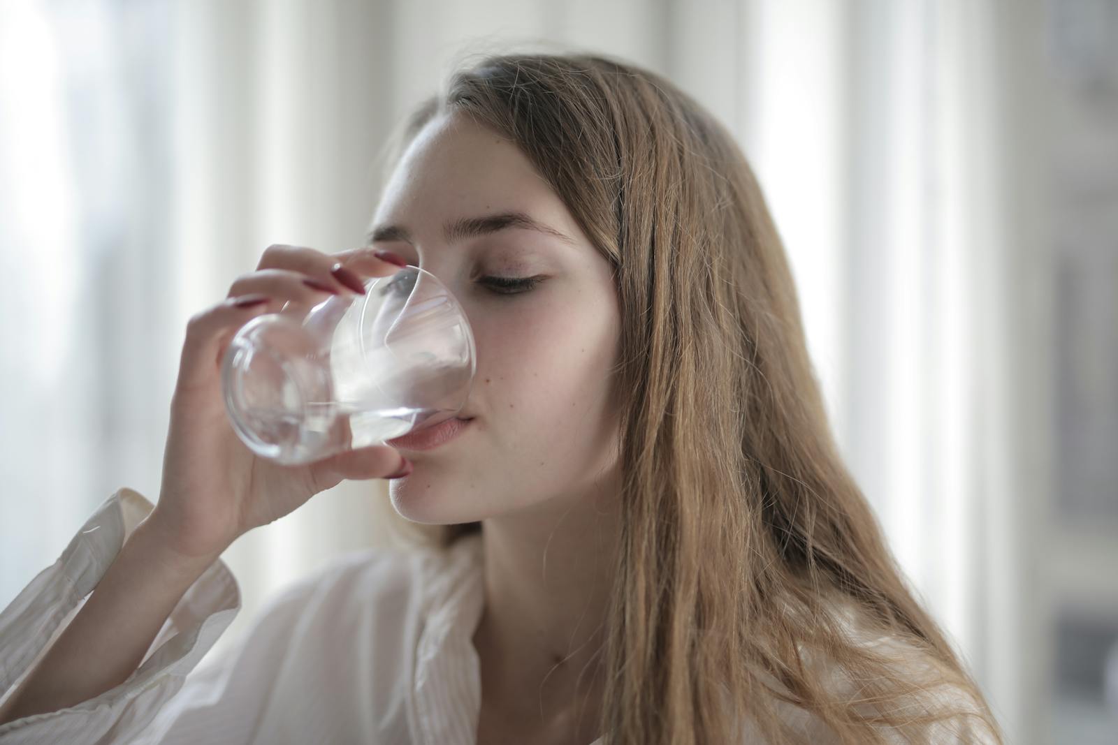 Woman drinking water in natural light