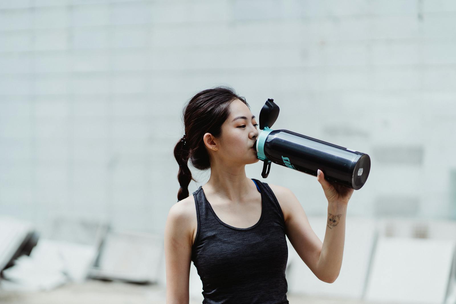 Woman drinking water after exercise