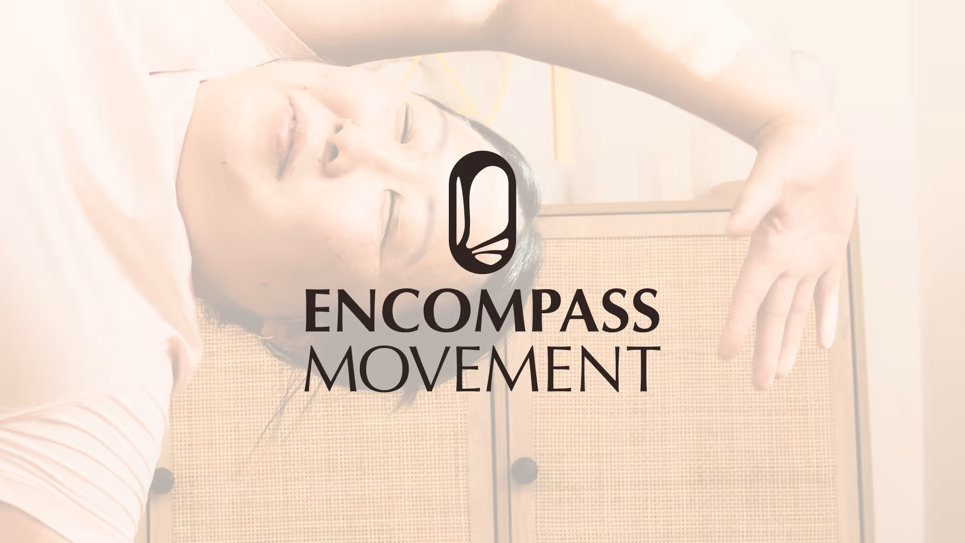 Person lying down with eyes closed, partially visible behind Encompass Movement logo.