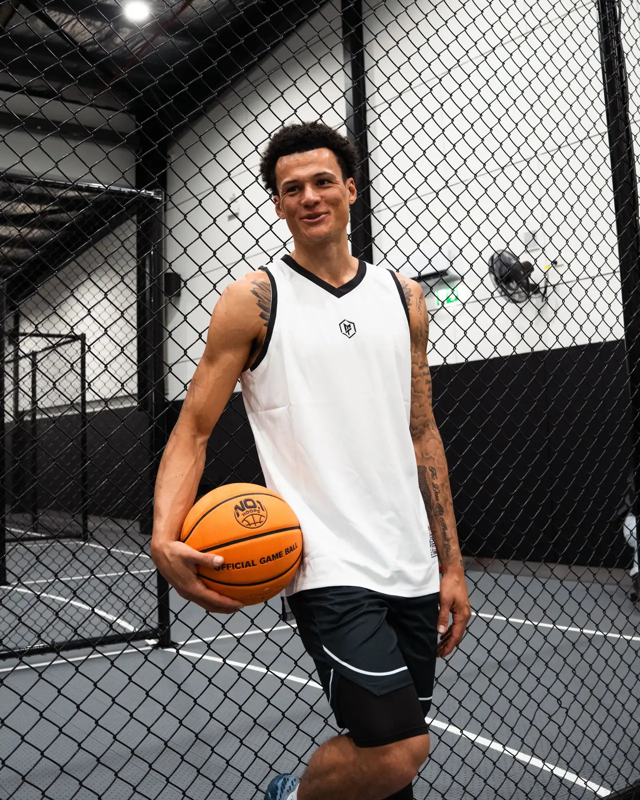 A player holding a basketball on an outdoor court at No 1 Hoops