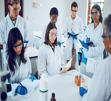 Group of medical students wearing lab coats, gloves, and safety goggles participating in a laboratory session.