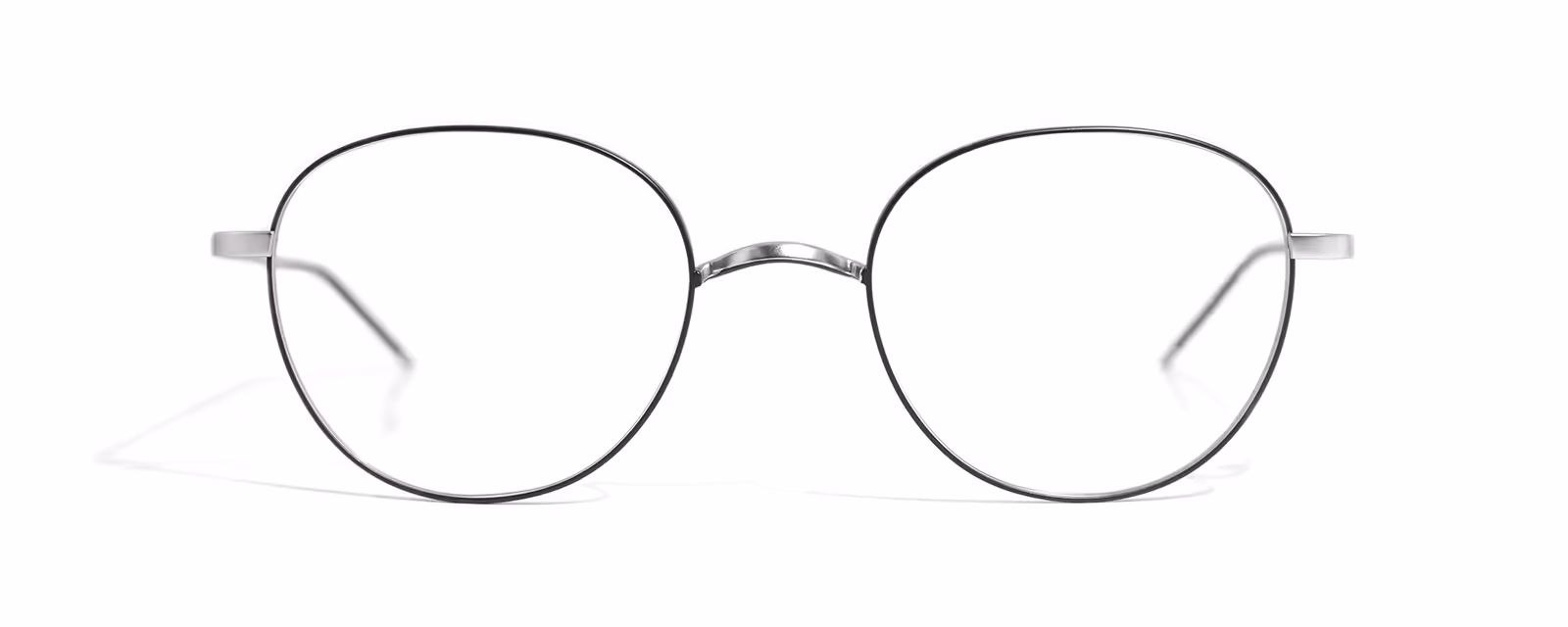 Pair of thin metal round eyeglass frames with clear lenses on white background.