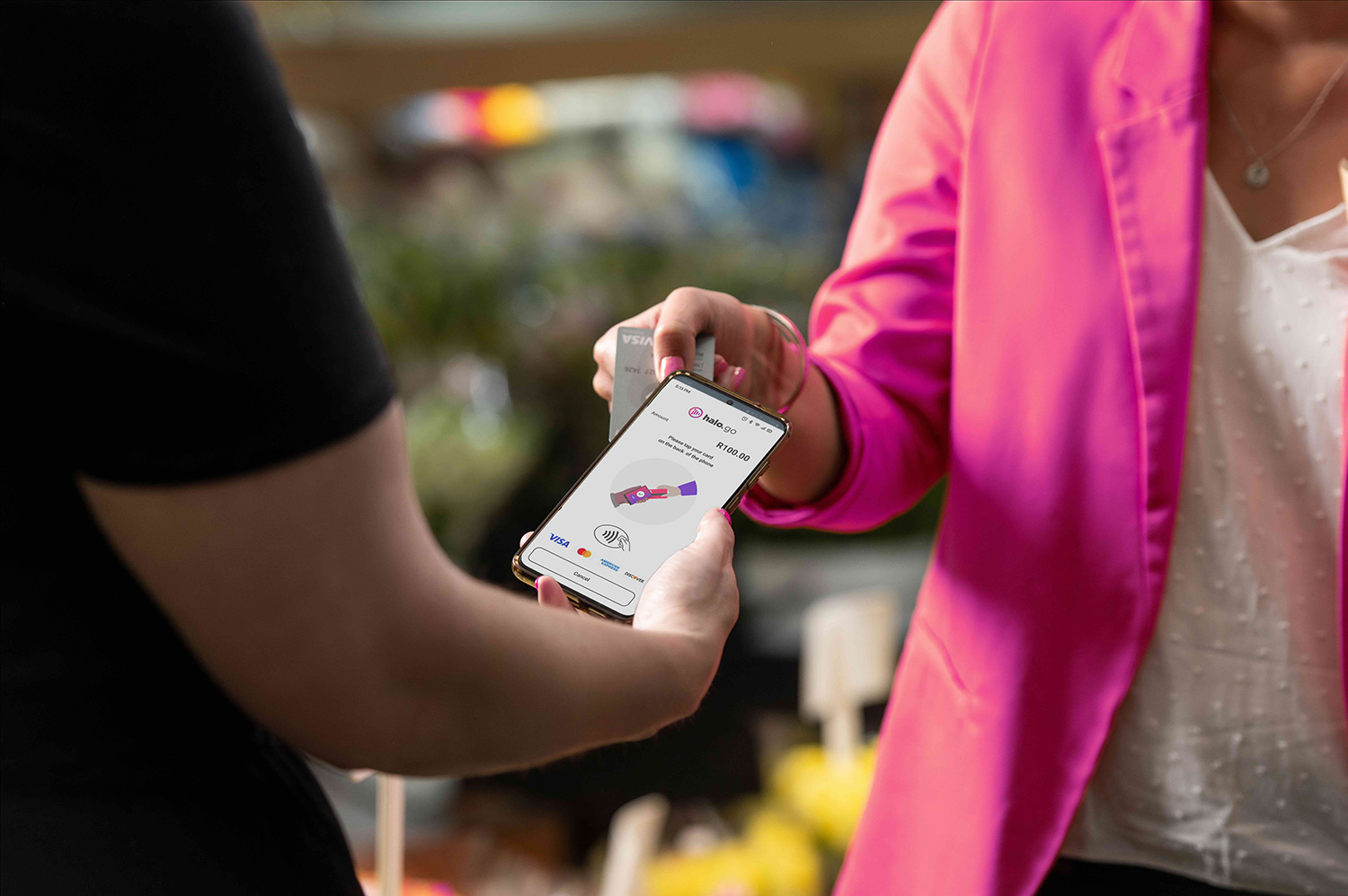 An image showing a PaymentGenes and Halo.Go transaction tasking place between a man and a woman