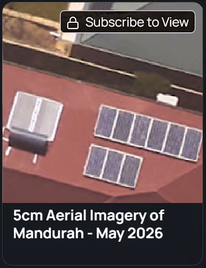 Aerial view of two buildings with solar panels installed on their roofs surrounded by trees and greenery.