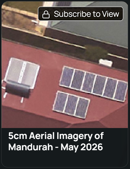 Aerial view of two buildings with solar panels installed on their roofs surrounded by trees and greenery.