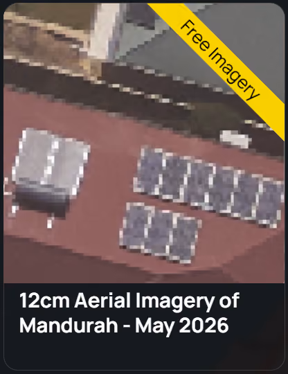 Aerial view of two buildings with solar panels installed on their roofs surrounded by trees and greenery.