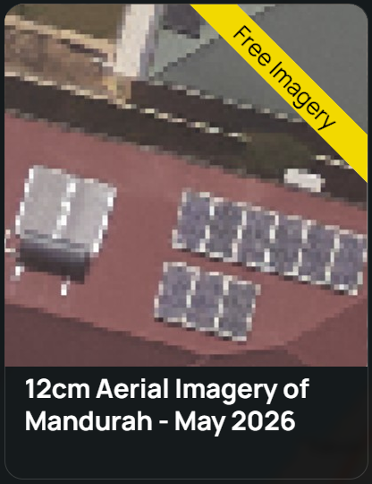 Aerial view of two buildings with solar panels installed on their roofs surrounded by trees and greenery.