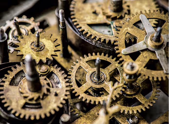 מערכת של גלגלי שיניים מתכתיים ישנים ומורכבים במכונה.
