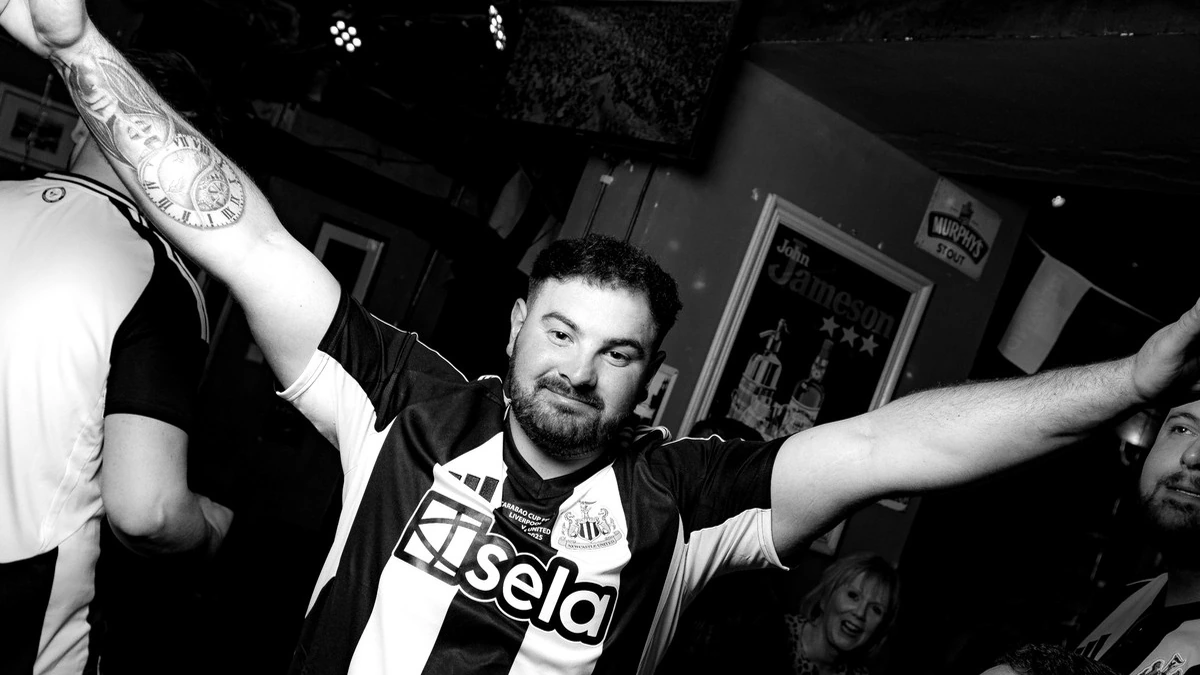 Football supporter celebrating inside Waxy Malone's in Prague