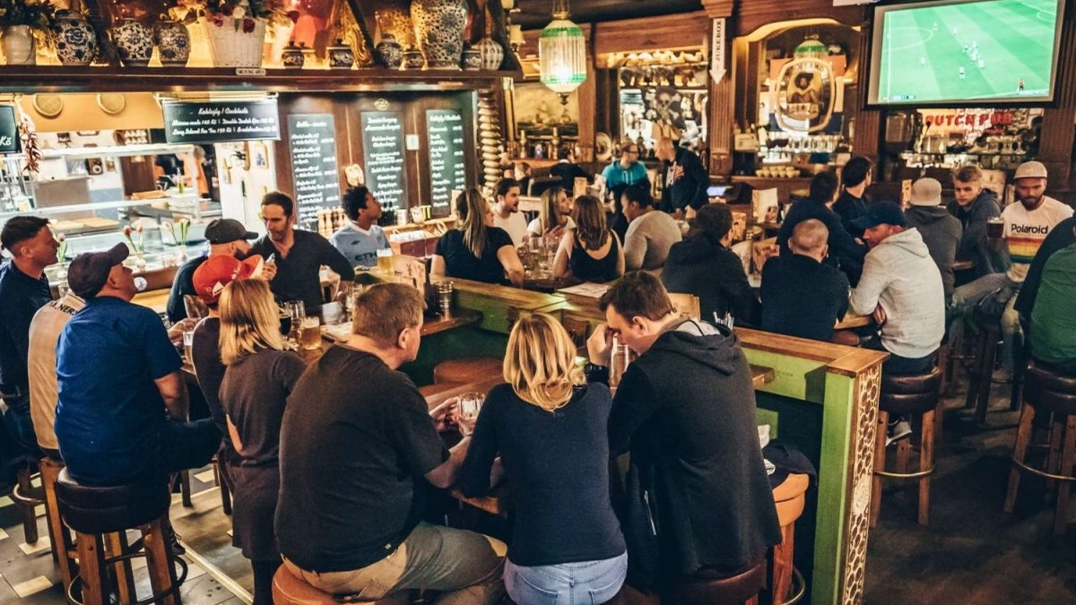 Sports broadcast and guests inside Dutch Pub Prague