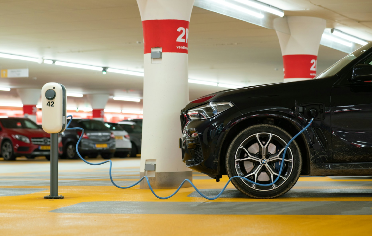 Schwarzes Auto auf einem E-Ladeparkplatz