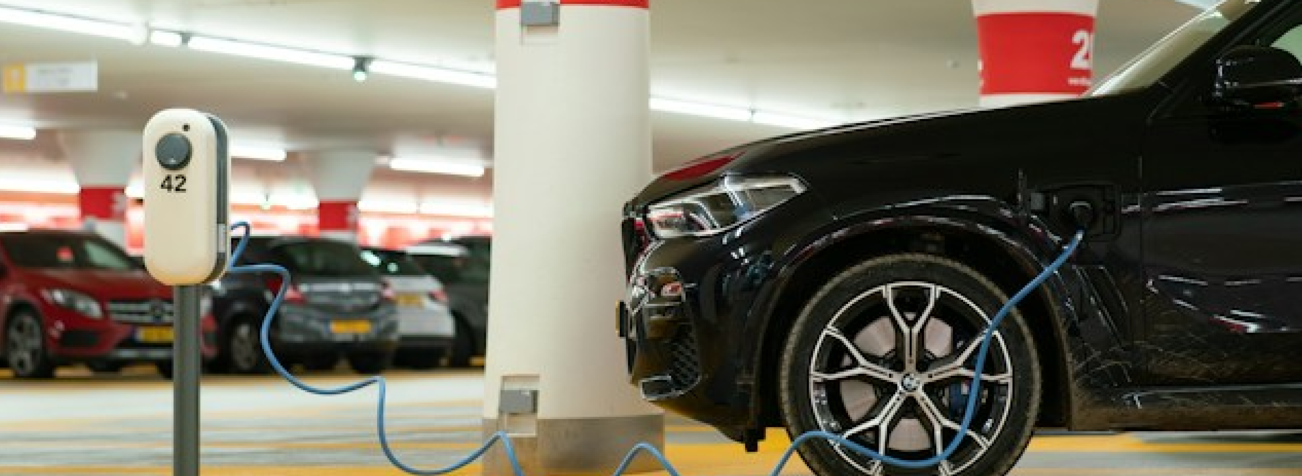 Schwarzes Auto auf einem E-Ladeparkplatz
