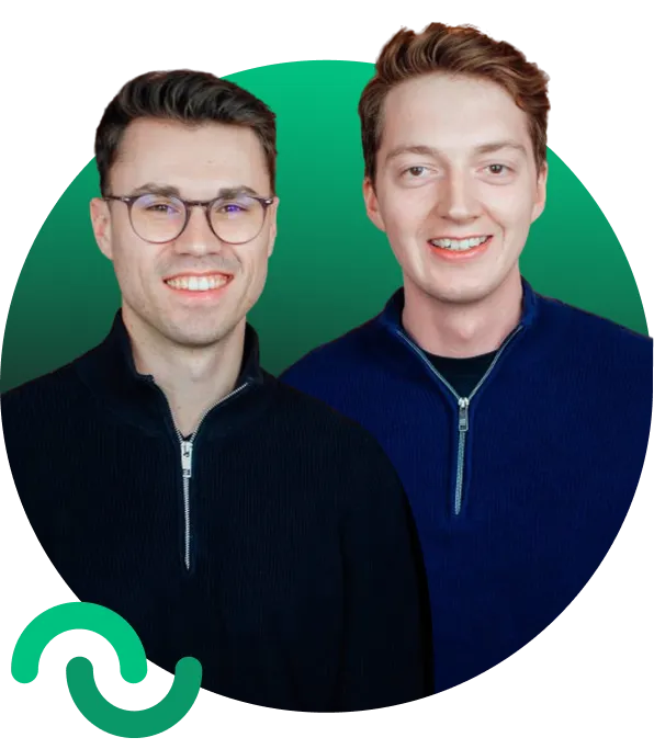 Two smiling young men wearing zip-up sweaters, one with glasses and dark hair, the other with light brown hair, standing in front of a green circular gradient background.