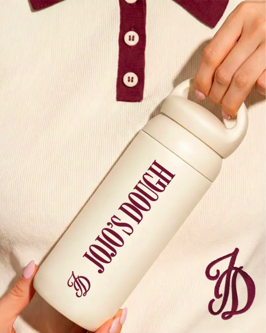 Gourde isotherme Jojo’s Dough tenue en main, avec logo et typographie de la marque