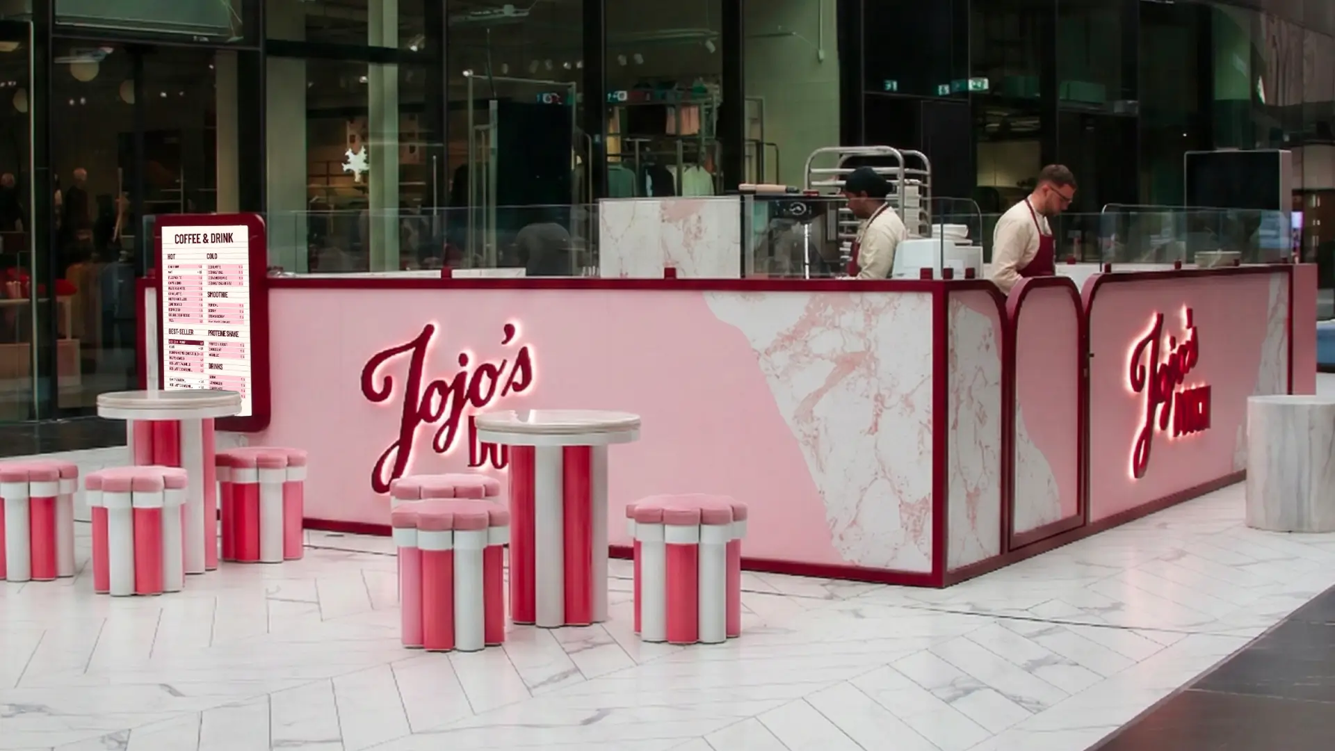 Comptoir Jojo’s Dough au design rose et marbre, avec mobilier intégré et logo lumineux dans un coffee shop