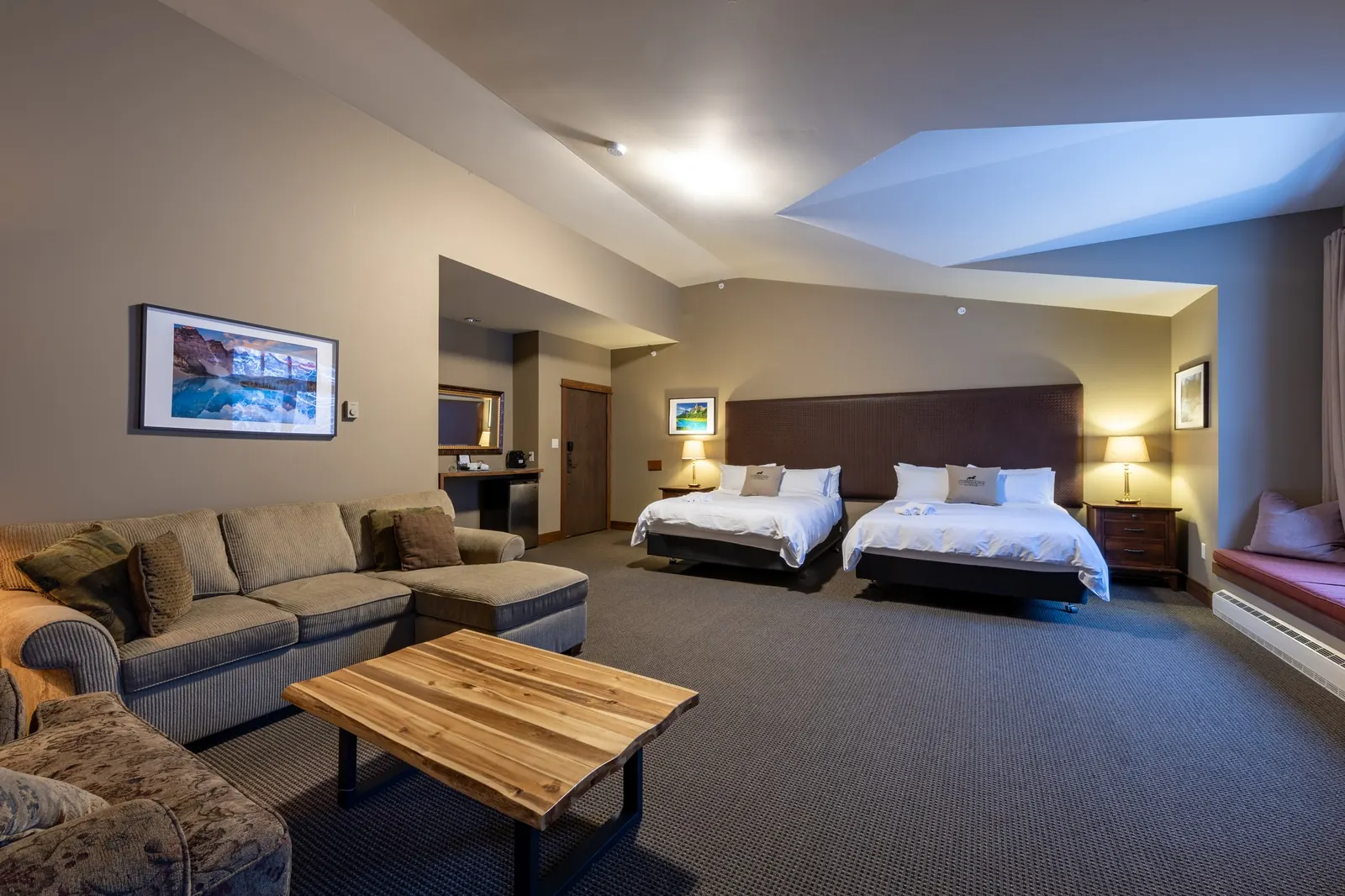 Two queen beds and a sitting area in a lodge guestroom