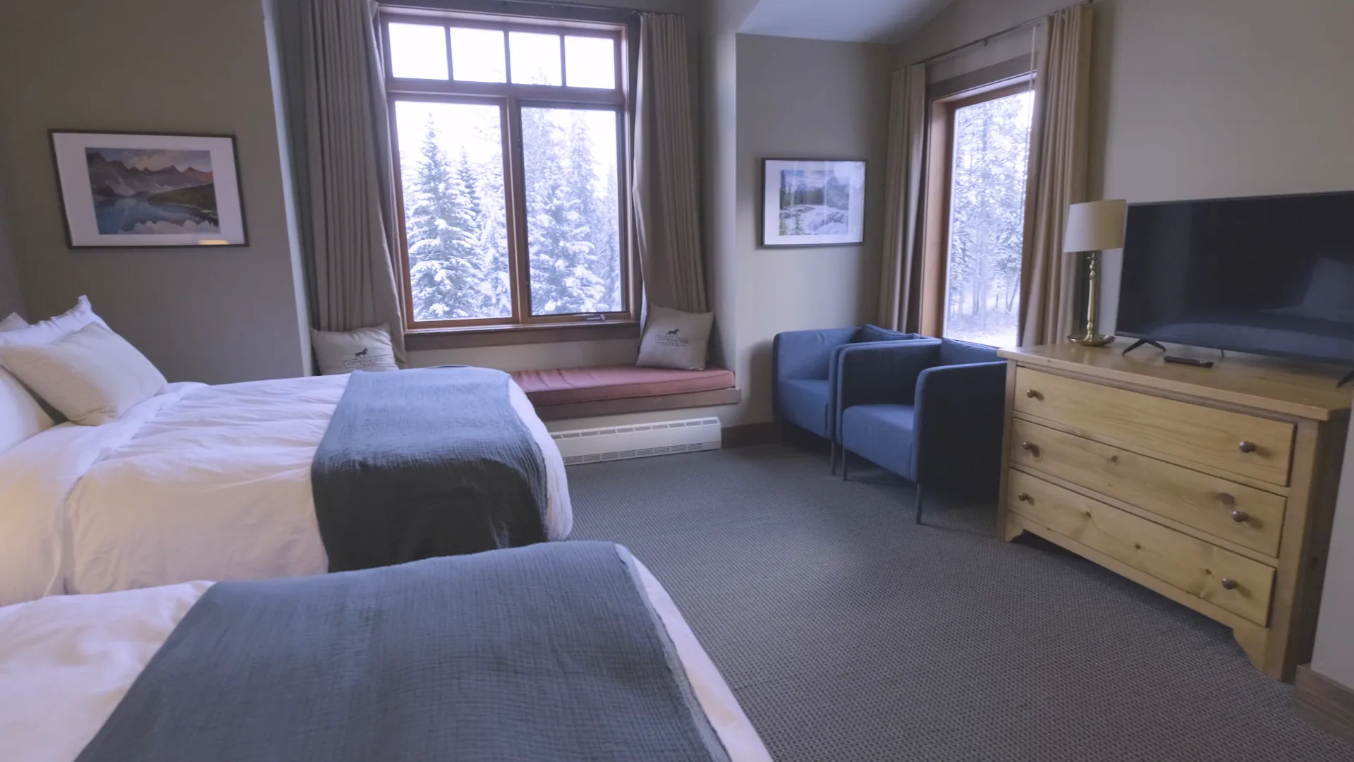Guestroom window seat, blue chairs and wooden dresser