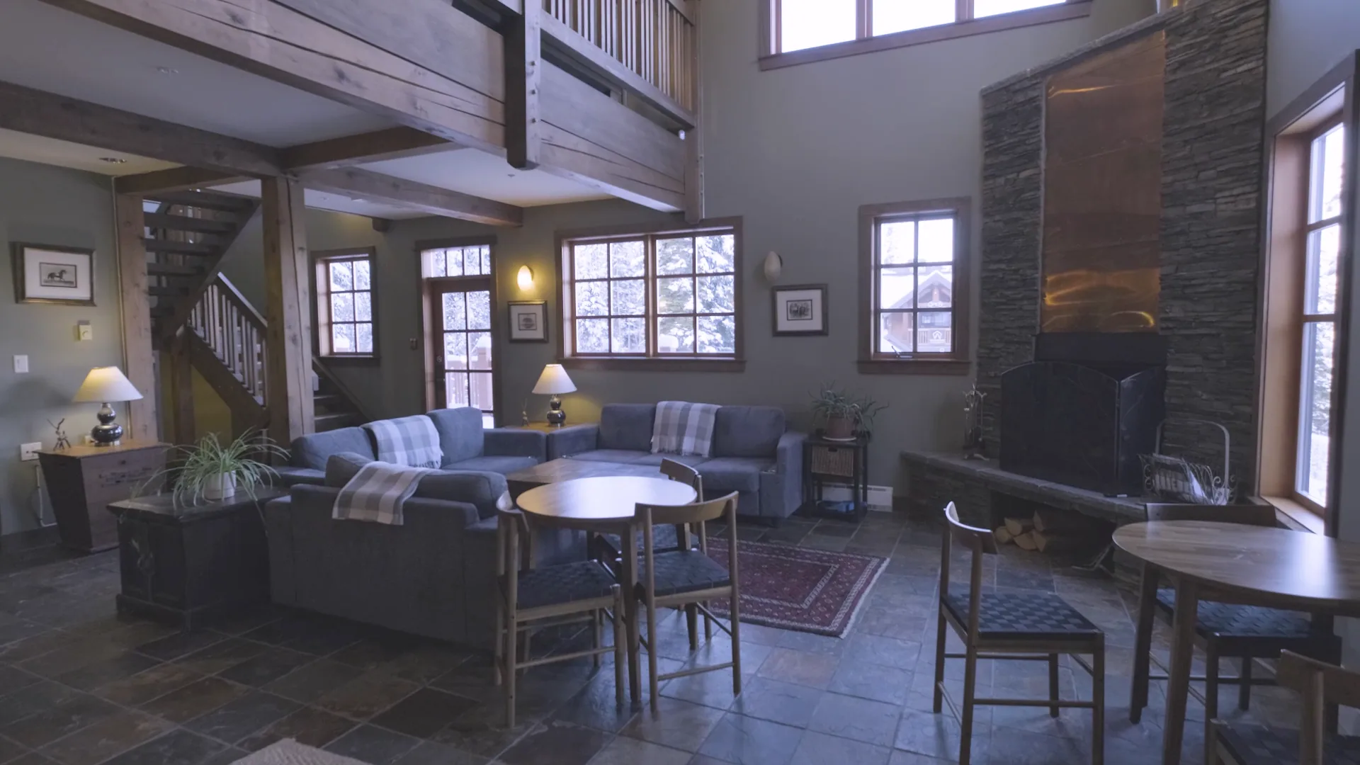 Timber beams, blue seating and the fireplace in the shared lodge lounge