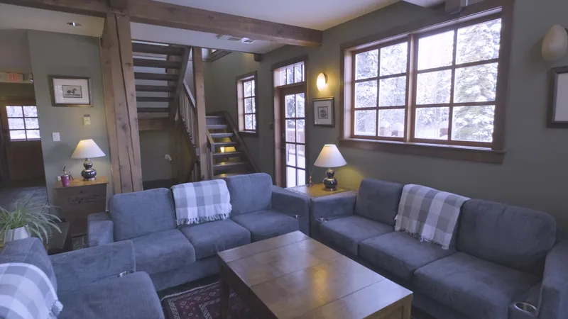 Blue sofas and timber staircase in the shared lodge lounge
