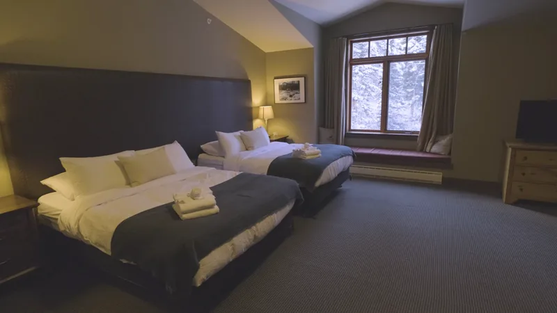 Two-queen guestroom with a snowy window view