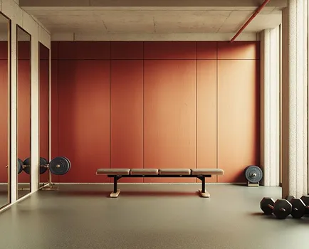 Sala de pesas con un banco en el centro, espejos en la pared izquierda y pesas en el suelo a la derecha y a la izquierda.