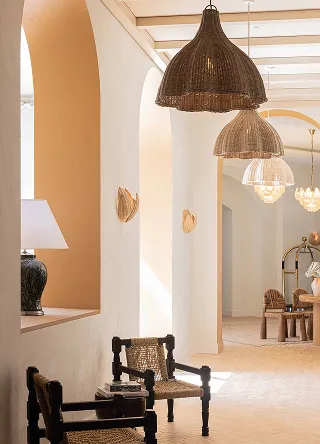 Interior luminoso con paredes y arcos blancos, alas de rata y pisos de madera negra con tejidos adyacentes.