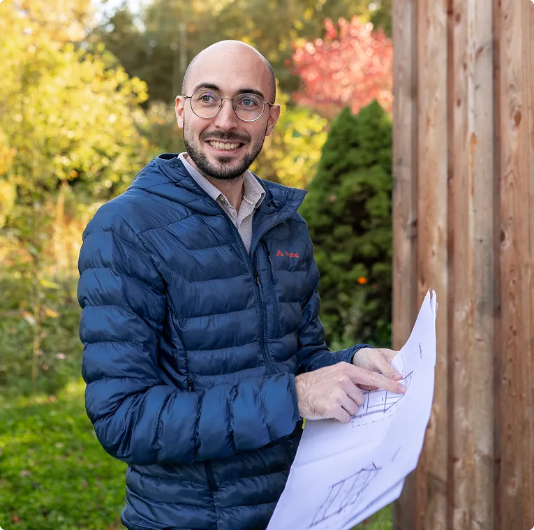 Vor-Ort-Termin: Energieberater mit Plänen am Gebäude