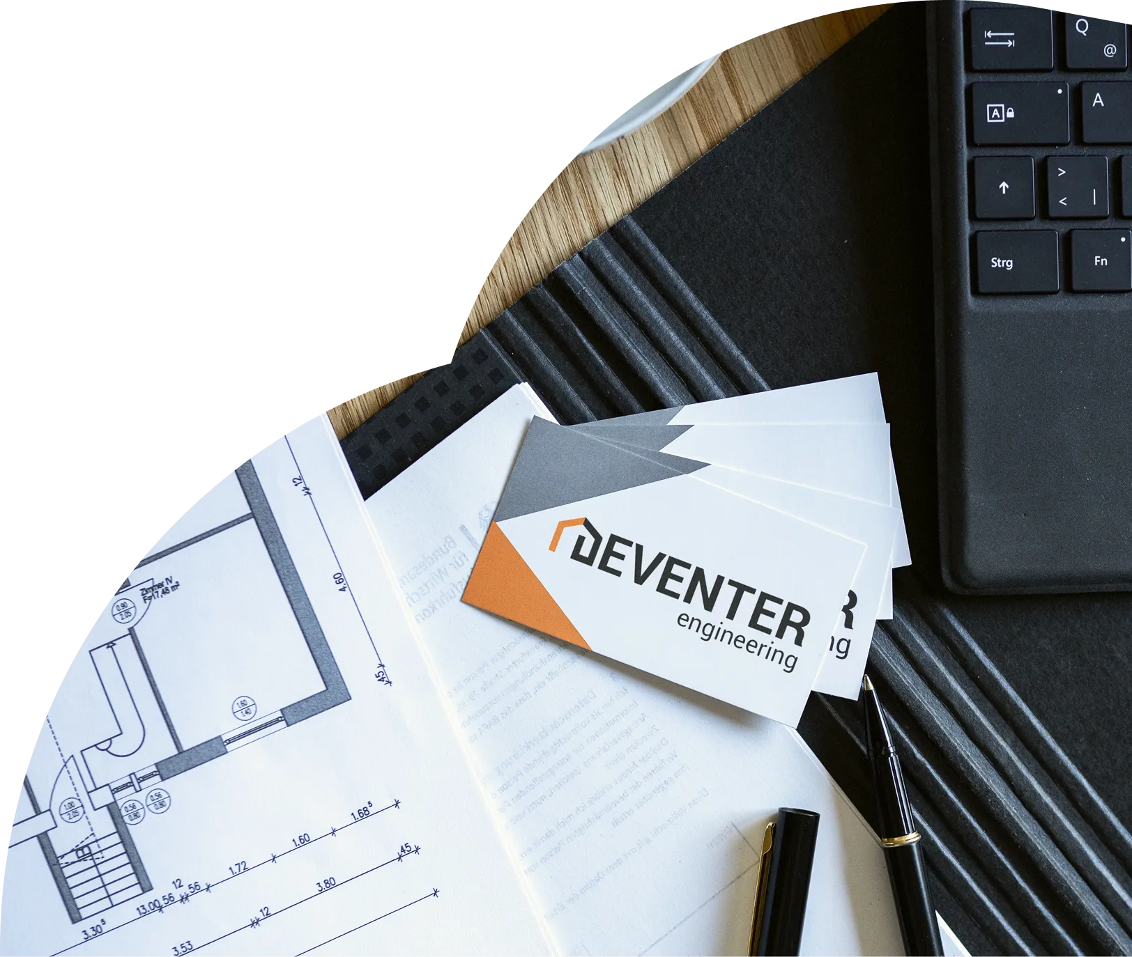 Planungsunterlagen und Visitenkarte von Deventer Engineering auf dem Schreibtisch