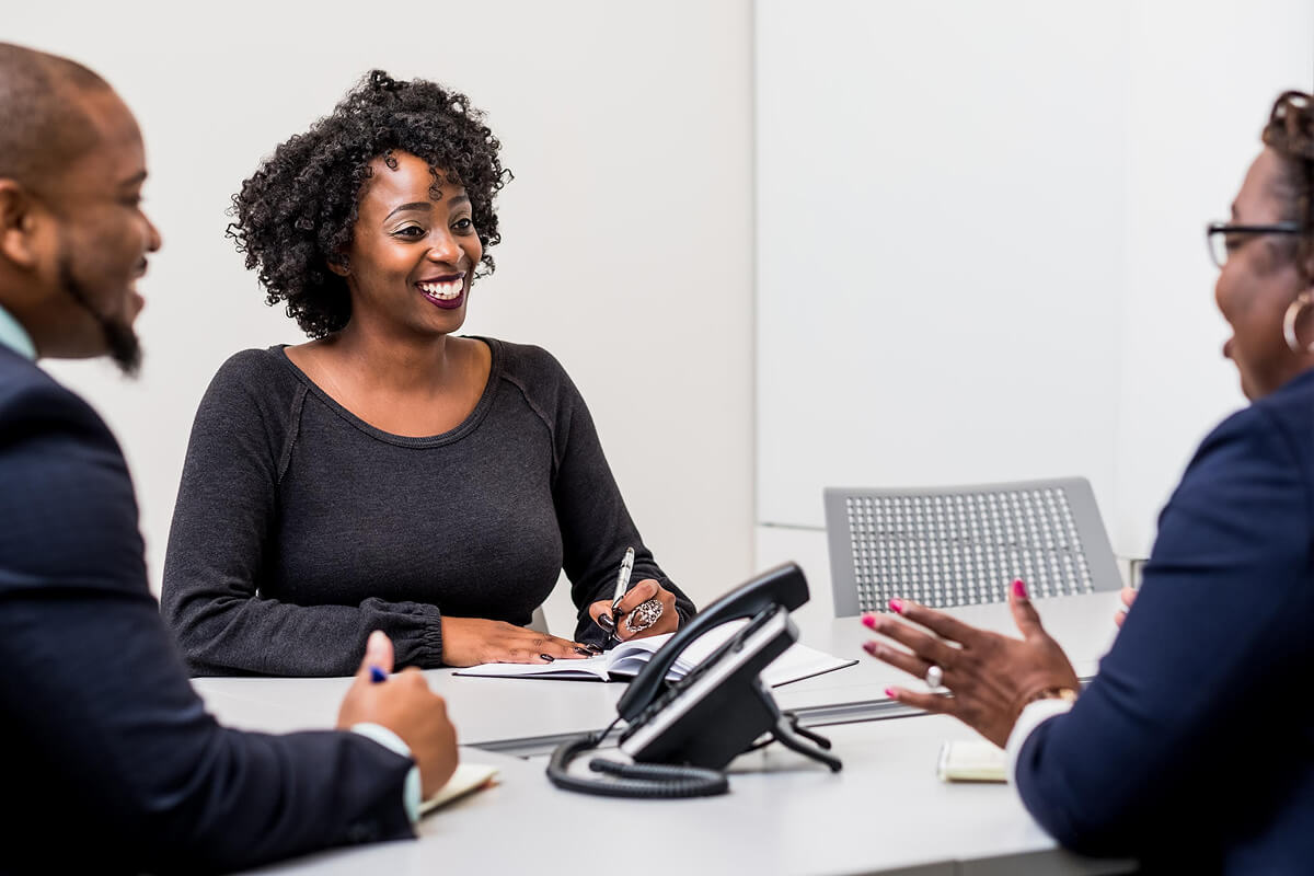 Job fair attendees exchanging documents at an employer information table.
