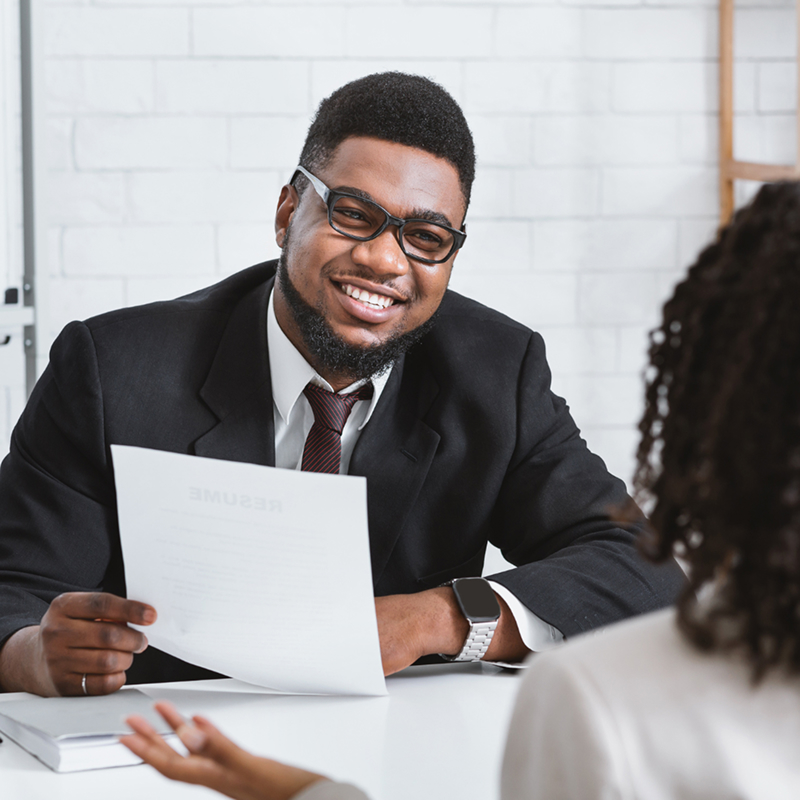 Job fair participant speaking with staff during a one-on-one conversation at a table