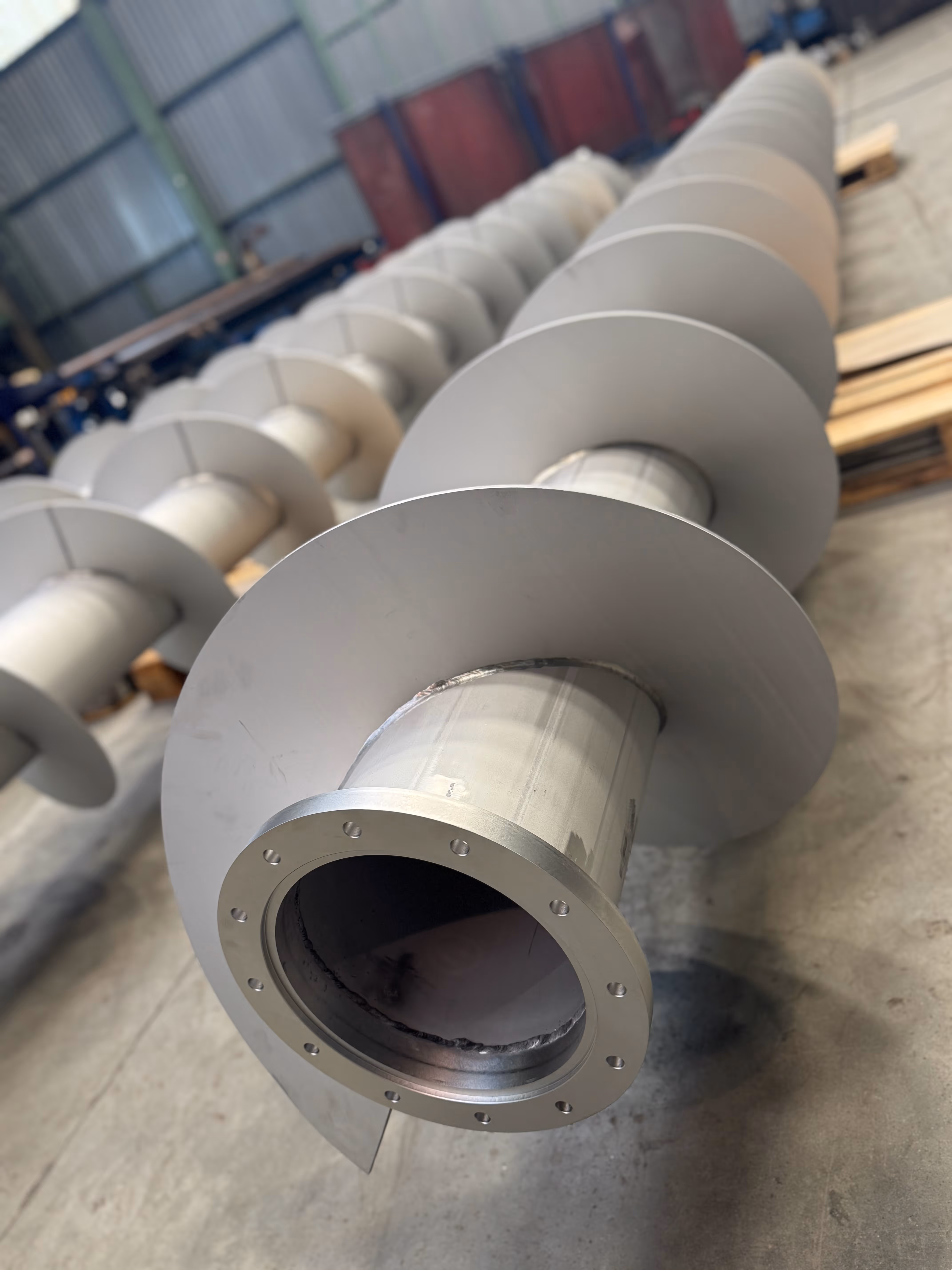 Two large metal industrial containers loaded on a flatbed semi-trailer in the open.