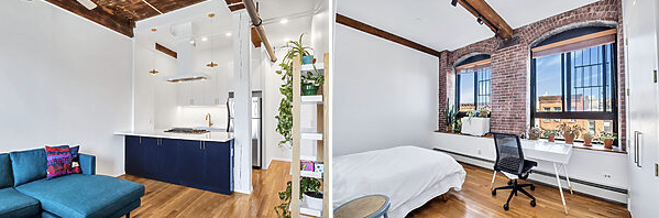 Modern apartment interior showing a kitchen with blue cabinets and a teal sofa on the left, and a bedroom with exposed brick walls, large windows, and a desk with a chair on the right.