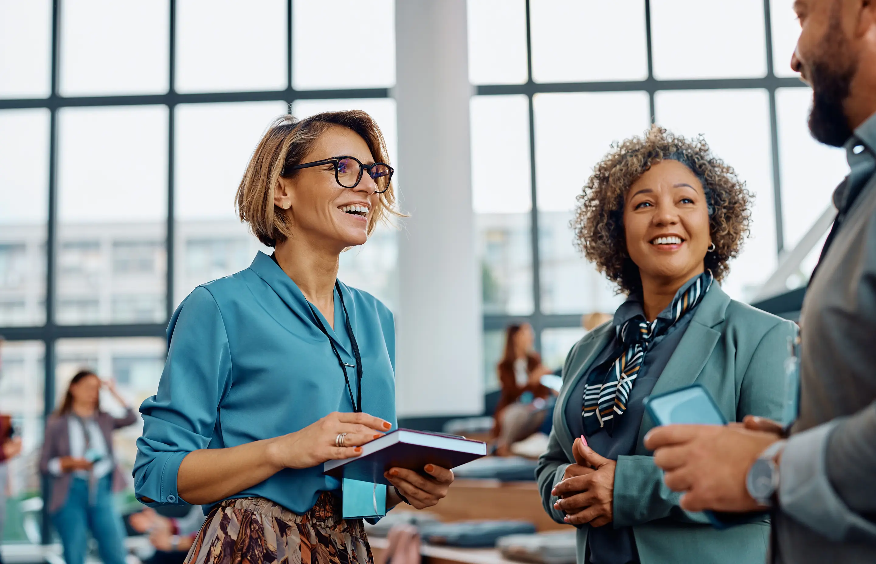 Person wearing a black sweater holding a smartphone displaying a map while sitting in a yellow car.