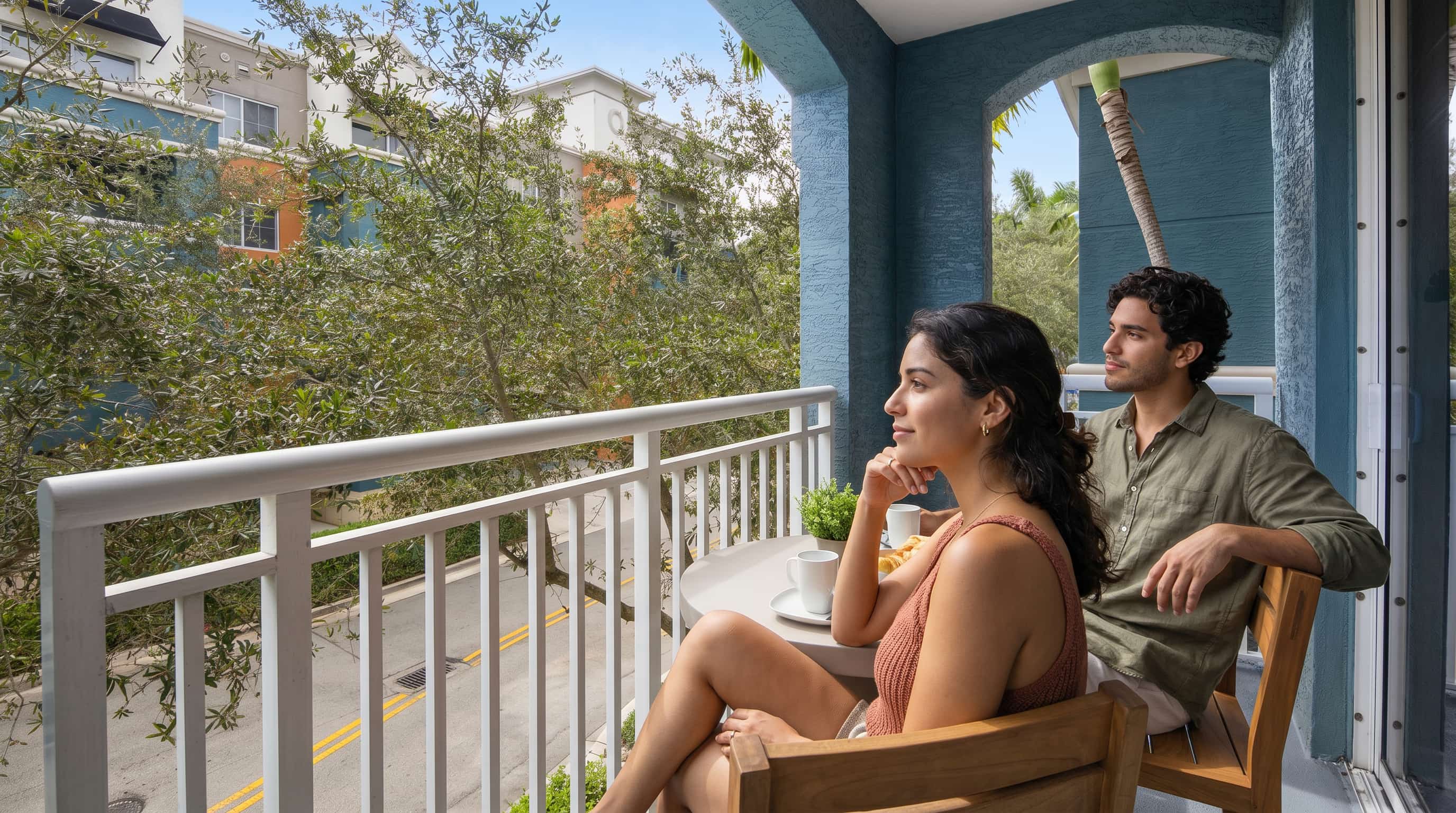 A couple sitting on the balcony of a luxury apartment