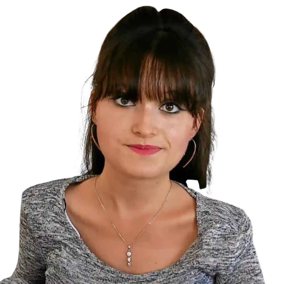 Homme avec barbe et cheveux courts portant une chemise grise à motifs, regardant vers l'avant avec un léger sourire.