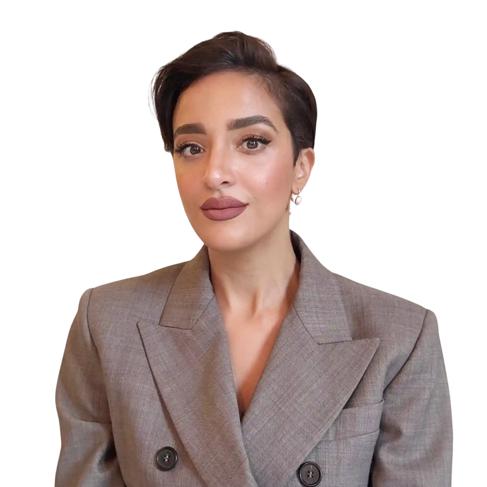 Homme avec barbe et cheveux courts portant une chemise grise à motifs, regardant vers l'avant avec un léger sourire.