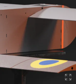 Close-up of a dark brown and beige aircraft wing section with a blue and yellow roundel symbol.