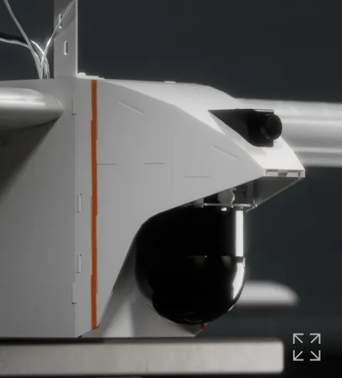 Close-up of a white robotic device with a black camera lens and sensor mounted on a gray platform against a dark background.