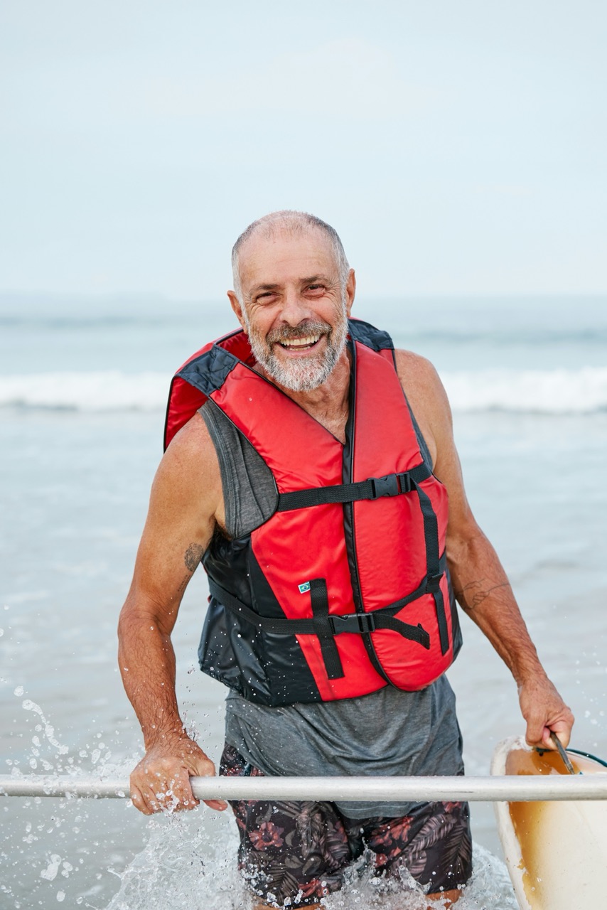 Smiling older man wearing a red life vest