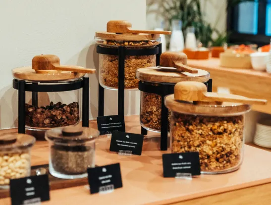 Elegant presentation of self-service cereals and nuts in glass and wooden containers at a buffet