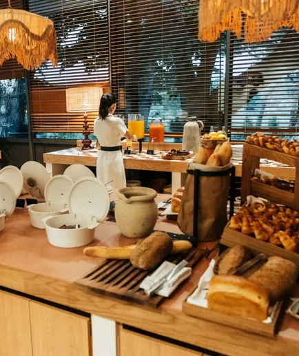 Breakfast buffet in a bright setting with Venetian blinds and textured light fixtures