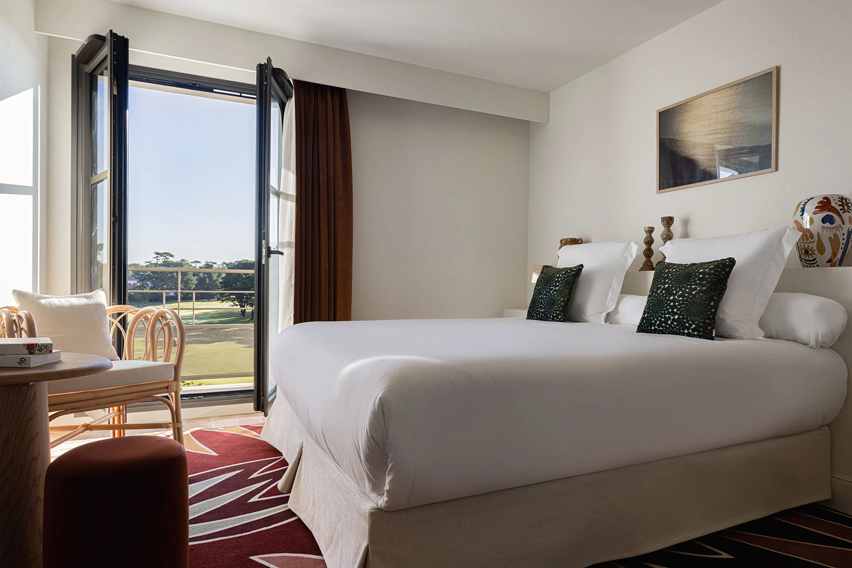 Double hotel room with white beds, exterior view, French door, and red patterned rug.