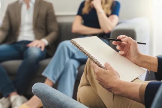 Continuous line drawing of a man and woman holding hands and facing each other.