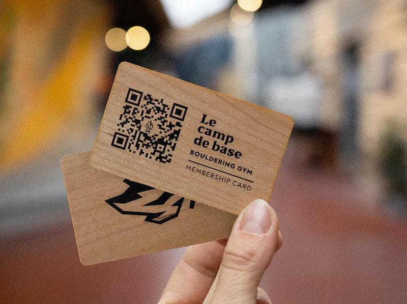 Photo d'une main tenant une carte de membre de la salle d'escalade Camp de Base