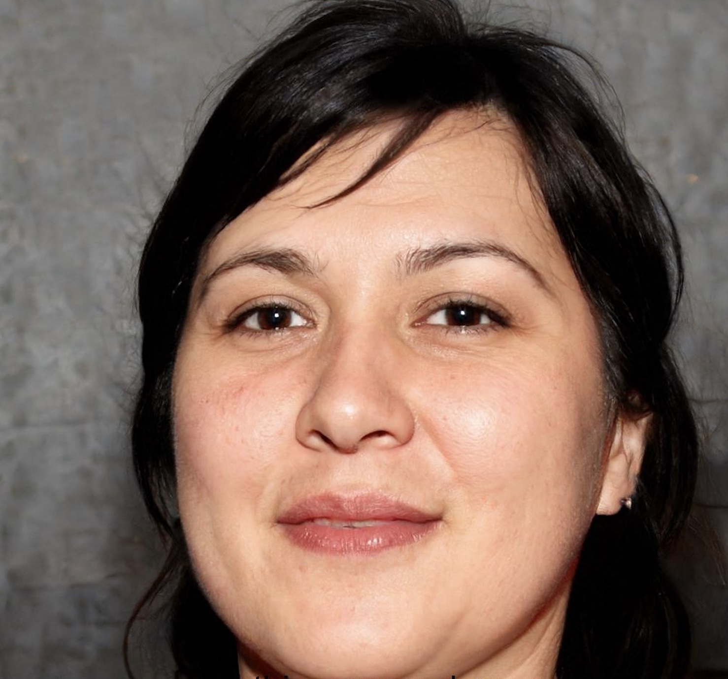 Portrait of a woman with short black hair against gray background