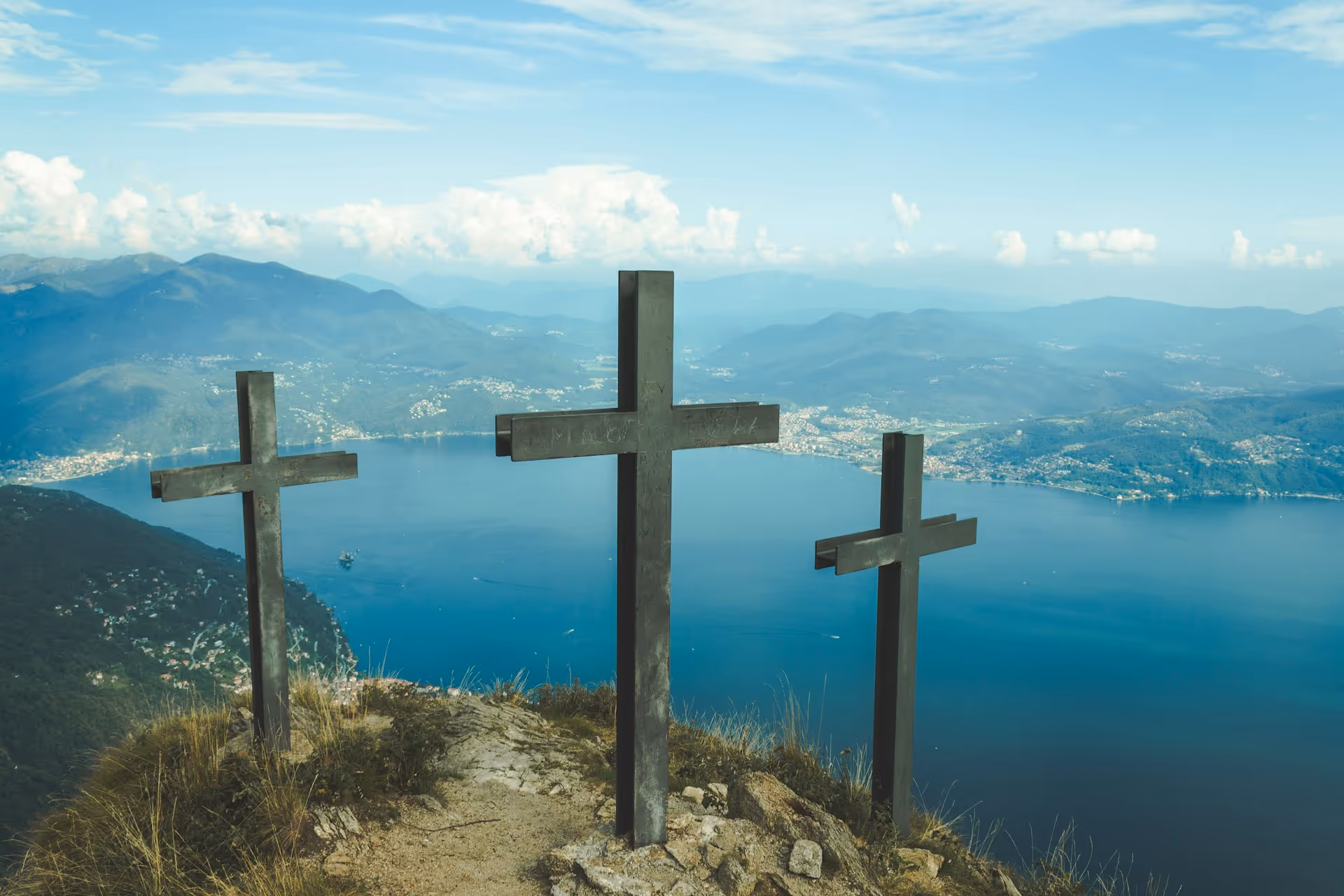 Three crosses on a mountaintop overlooking a blue lake